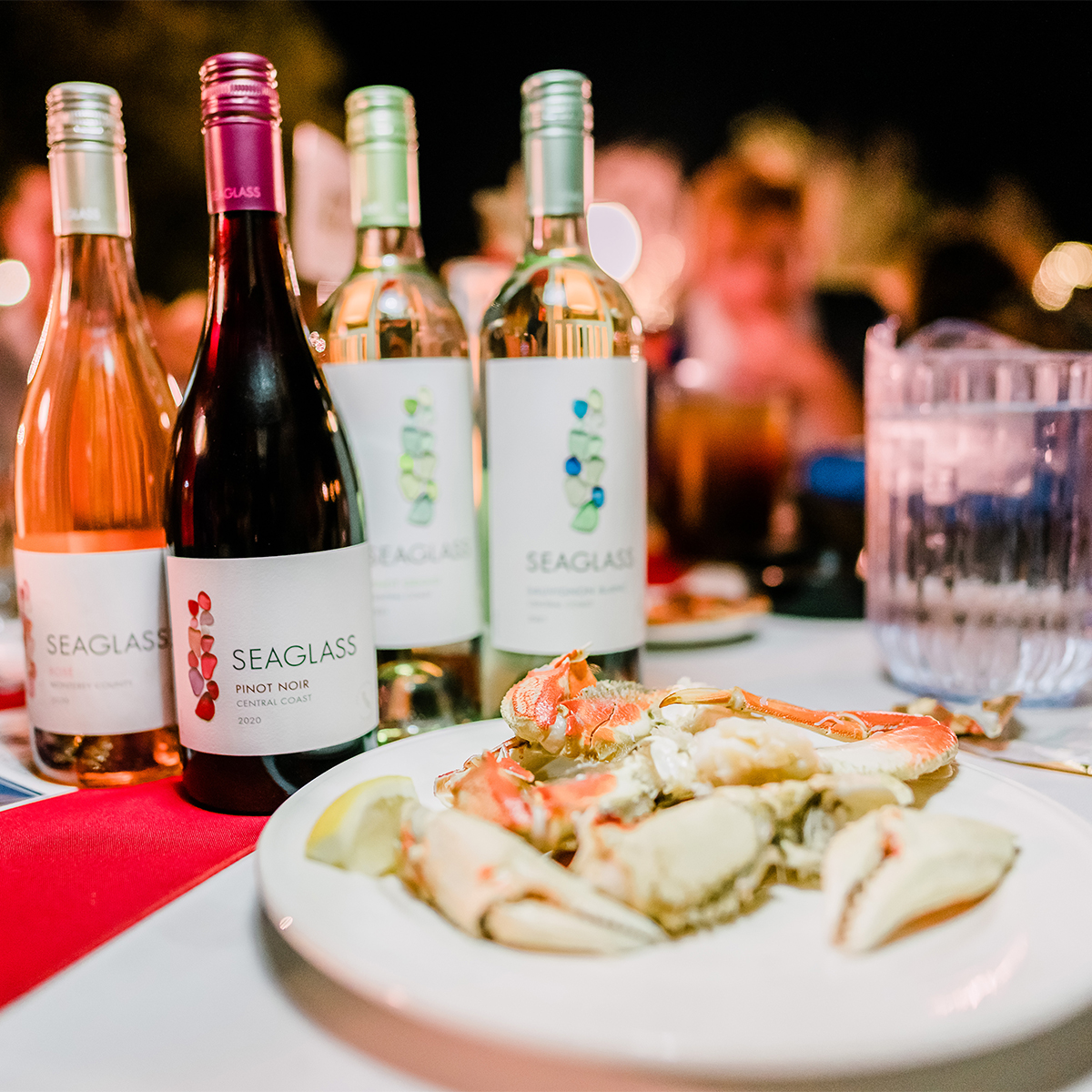 CASA Crab Feed Photos_Crab on a plate accompanied by several bottles of Seaglass Wine